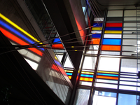 818242 Afbeelding van een aantal gekleurde glasvlakken in de hal van het kantoorgebouw van de Belastingdienst ...